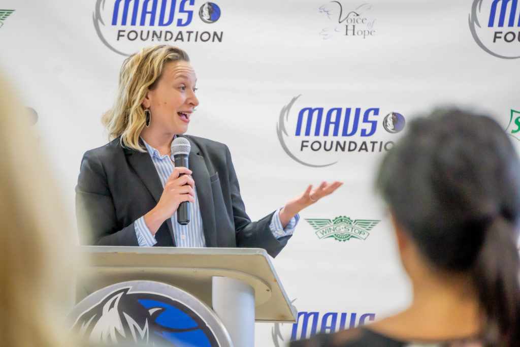 Wingstop Charities Chairman Marisa Carona speaking at the Mavs Foundation court dedication.