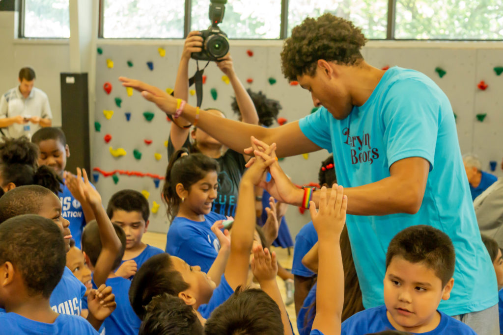 Dallas Mavs player Justin Jackson coaches the children for a basketball clinic